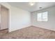 This bedroom features neutral carpeting and a window that lets in natural light at 7464 Edgecove Ct, Las Vegas, NV 89139
