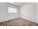 This bedroom features neutral carpeting and a window that lets in natural light at 7464 Edgecove Ct, Las Vegas, NV 89139