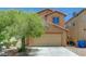 Two-story home with a two-car garage and drought-tolerant landscaping in the front yard at 7464 Edgecove Ct, Las Vegas, NV 89139