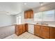 Well-lit kitchen with stainless steel sink, wooden cabinets, and a window offering natural light and backyard views at 7464 Edgecove Ct, Las Vegas, NV 89139