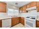 Functional kitchen featuring a gas range, white appliances, and wooden cabinets, offering essential amenities for meal preparation at 7464 Edgecove Ct, Las Vegas, NV 89139