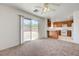 Bright living room with sliding glass doors to the backyard, adjacent to kitchen with wood cabinets and breakfast bar at 7464 Edgecove Ct, Las Vegas, NV 89139