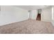 Spacious, carpeted living room with a view of the staircase and entry door, offering ample space at 7464 Edgecove Ct, Las Vegas, NV 89139