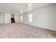 Spacious, carpeted living room with stairs to the upper level and plenty of natural light, perfect for relaxing and entertaining at 7464 Edgecove Ct, Las Vegas, NV 89139