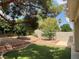 Manicured backyard with artificial turf, rock accents, and mature trees at 7620 Donald Nelson Ave, Las Vegas, NV 89131