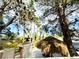 Charming backyard featuring a shady tiki hut, mature trees, and lush landscaping at 8156 Blue Hope Diamond Ln, Las Vegas, NV 89139