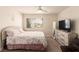 Bright bedroom featuring a large window with blinds, a dresser with a TV, and carpeted floors at 8600 W Charleston Blvd # 2187, Las Vegas, NV 89117