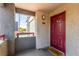 Apartment entrance with welcome mat, burgundy door, and unit number, providing a warm welcome at 8600 W Charleston Blvd # 2187, Las Vegas, NV 89117
