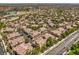 Expansive aerial view showcases a neighborhood featuring terra cotta tile roofs and mature trees, blending suburban living at 8737 Red Brook Dr # 204, Las Vegas, NV 89128