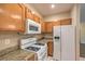 Bright kitchen featuring white appliances, granite countertops, and light wood cabinets at 8737 Red Brook Dr # 204, Las Vegas, NV 89128