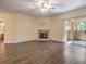Open-plan living room with wood floors, fireplace, ceiling fan and sliding doors to balcony at 8737 Red Brook Dr # 204, Las Vegas, NV 89128