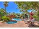 Community pool area with hot tub, lounge chairs, umbrellas, and lush landscaping at 8737 Red Brook Dr # 204, Las Vegas, NV 89128
