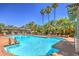 Resort-style pool area with lounge chairs, palm trees, and clear blue water at 8737 Red Brook Dr # 204, Las Vegas, NV 89128