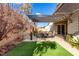 Inviting backyard with a patio, a pergola, artificial turf, and desert landscaping at 8941 Indigo Rose St, Las Vegas, NV 89166