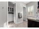 Bright bathroom with wood-look tile, walk-in closet, a modern vanity, and plantation shutters at 8941 Indigo Rose St, Las Vegas, NV 89166