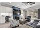 Cozy living room with a fireplace, ceiling fan, sliding glass door to the patio, and modern furniture at 8941 Indigo Rose St, Las Vegas, NV 89166