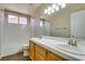 Bright bathroom features double sinks, wood cabinets, and shower over tub at 904 Big Horn St, Henderson, NV 89002