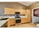 Kitchen featuring light wood cabinets, a stainless steel range, and tile flooring at 904 Big Horn St, Henderson, NV 89002