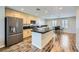 An open layout kitchen with a black countertop island, stainless steel fridge, and wood-look flooring at 9050 W Tropicana Ave # 1015, Las Vegas, NV 89147
