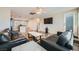 A modern living room with wood-look flooring, a ceiling fan, and black leather sofas at 9050 W Tropicana Ave # 1015, Las Vegas, NV 89147