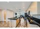 An open layout living room with a black countertop kitchen island, and dark leather sofas at 9050 W Tropicana Ave # 1015, Las Vegas, NV 89147