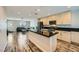 An open layout living room with a black countertop kitchen island, and a dark leather sofa at 9050 W Tropicana Ave # 1015, Las Vegas, NV 89147