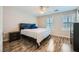 A bright main bedroom featuring wood-look floors, a ceiling fan, and a large bed at 9050 W Tropicana Ave # 1015, Las Vegas, NV 89147