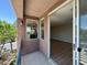 Covered balcony with an open door offering views to a living room with wood flooring at 9116 Vista Greens Way # 104, Las Vegas, NV 89134