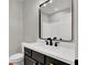 Bathroom features a granite countertop, modern black faucet, and a large framed mirror at 9116 Vista Greens Way # 104, Las Vegas, NV 89134
