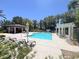 Community pool featuring lounge chairs, sun umbrellas, covered patio, set under blue skies and mature palm trees at 9116 Vista Greens Way # 104, Las Vegas, NV 89134