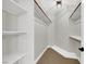 Walk-in closet with white shelving and wood rods for ample storage at 9116 Vista Greens Way # 104, Las Vegas, NV 89134
