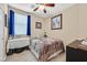 Bedroom features tan walls, carpet, decor, a window with blue curtains, and a full size bed with brown bedding at 9118 Mount Wilson St, Las Vegas, NV 89113