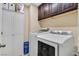 Laundry room features a white washer and dryer, dark cabinets, and white storage cabinet with bi-fold doors at 9118 Mount Wilson St, Las Vegas, NV 89113