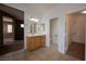 Bathroom featuring a tiled floor, wooden vanity, and access to a walk-in closet at 9312 Poseidon Valley Ave, Las Vegas, NV 89178
