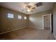 Spacious bedroom featuring three windows, a ceiling fan, and neutral carpeting at 9312 Poseidon Valley Ave, Las Vegas, NV 89178