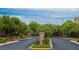 Street view of the community entrance featuring a decorative gate, landscaping, and sidewalks at 9312 Poseidon Valley Ave, Las Vegas, NV 89178