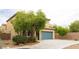 View of a two-story home with drought-resistant landscaping, a blue garage door, and a concrete driveway at 9312 Poseidon Valley Ave, Las Vegas, NV 89178