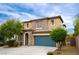 Charming two-story home featuring a tile roof, stone accents, and a blue two-car garage door at 9312 Poseidon Valley Ave, Las Vegas, NV 89178
