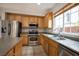 Well-lit kitchen with stainless steel appliances, wooden cabinetry, and tile flooring at 9312 Poseidon Valley Ave, Las Vegas, NV 89178