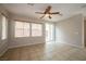Spacious living room featuring tile flooring, neutral walls, a ceiling fan, and backyard access at 9312 Poseidon Valley Ave, Las Vegas, NV 89178