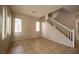 Neutral-toned living room with tile flooring, bright windows, and stairs to the second level at 9312 Poseidon Valley Ave, Las Vegas, NV 89178