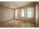 Neutral-toned living room with tile flooring, arched windows, and a view of the front yard at 9312 Poseidon Valley Ave, Las Vegas, NV 89178