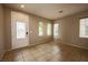 Neutral-toned living room with tile flooring, bright windows, and a clear view to the front entrance at 9312 Poseidon Valley Ave, Las Vegas, NV 89178