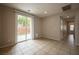 Bright living room featuring tile flooring, neutral walls, a sliding glass door, and backyard access at 9312 Poseidon Valley Ave, Las Vegas, NV 89178