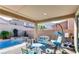 Charming covered back patio with mountain views, a sparkling pool, and cozy seating area at 9537 Wild Valley Ave, Las Vegas, NV 89148