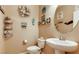 Coastal themed powder room with decorative wall art, mirror, toilet, and sink at 9537 Wild Valley Ave, Las Vegas, NV 89148