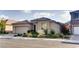 Attractive single-story home featuring desert landscaping, a tile roof, and an attached two-car garage at 9537 Wild Valley Ave, Las Vegas, NV 89148