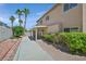 Backyard with a covered patio, lush greenery, and mature palm trees at 9746 Driftwood Island Ct, Las Vegas, NV 89148
