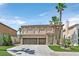Two-story home with a three-car garage, lush landscaping, and palm trees at 9746 Driftwood Island Ct, Las Vegas, NV 89148