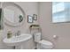 Charming powder room featuring a pedestal sink, decorative mirror, and neutral tones at , Henderson, NV 89044